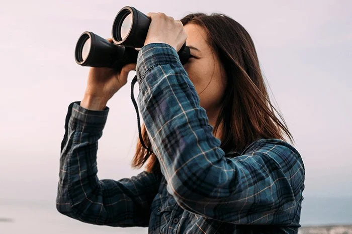 a woman looking through binoculars