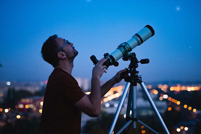man using a spotting scope in the city