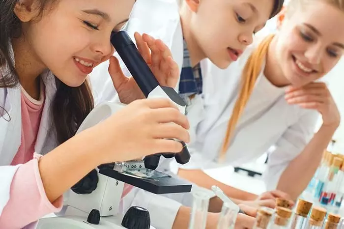 girl looking through a microscope